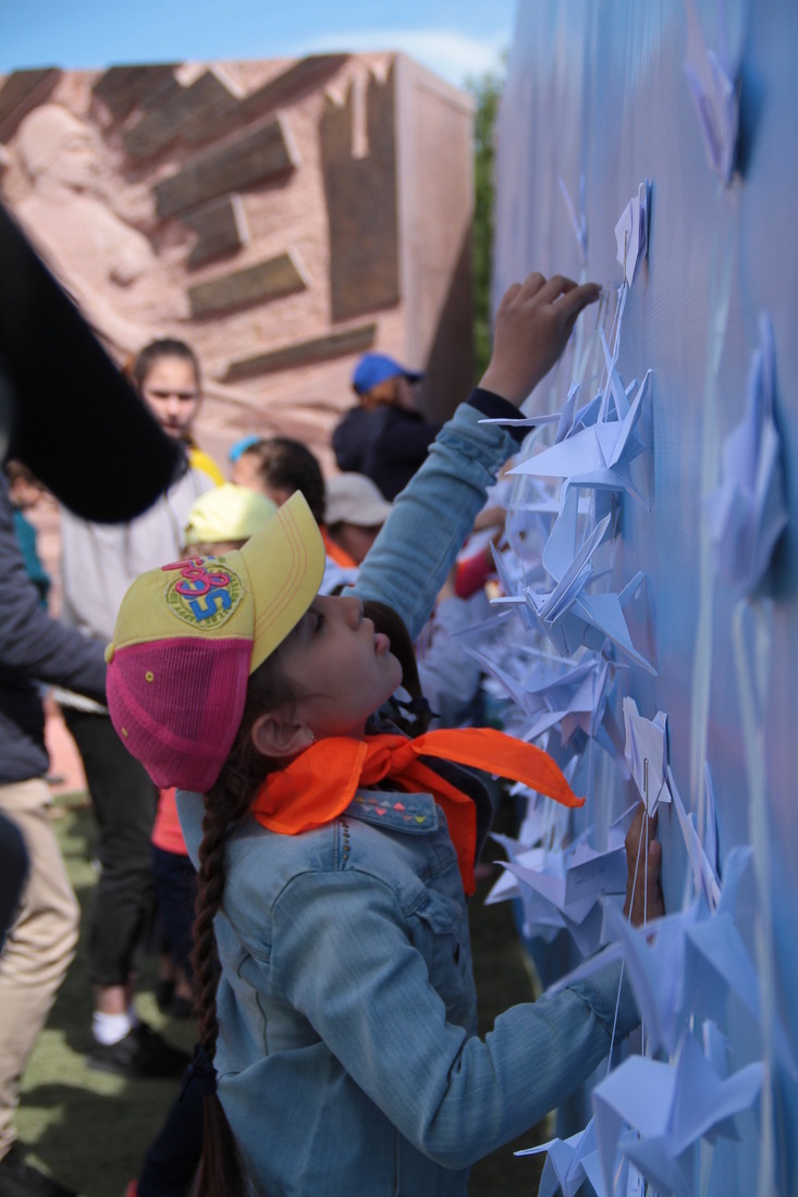 Дети изготовили белых бумажных журавлей своими руками и прикрепили их на стенде у мемориала «Воинская слава»